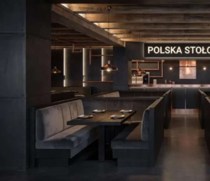 Industrialne, przyciemnione wnętrze Velokravinox z otwartym woodfired grillem i stalowo-drewnianymi detalami.